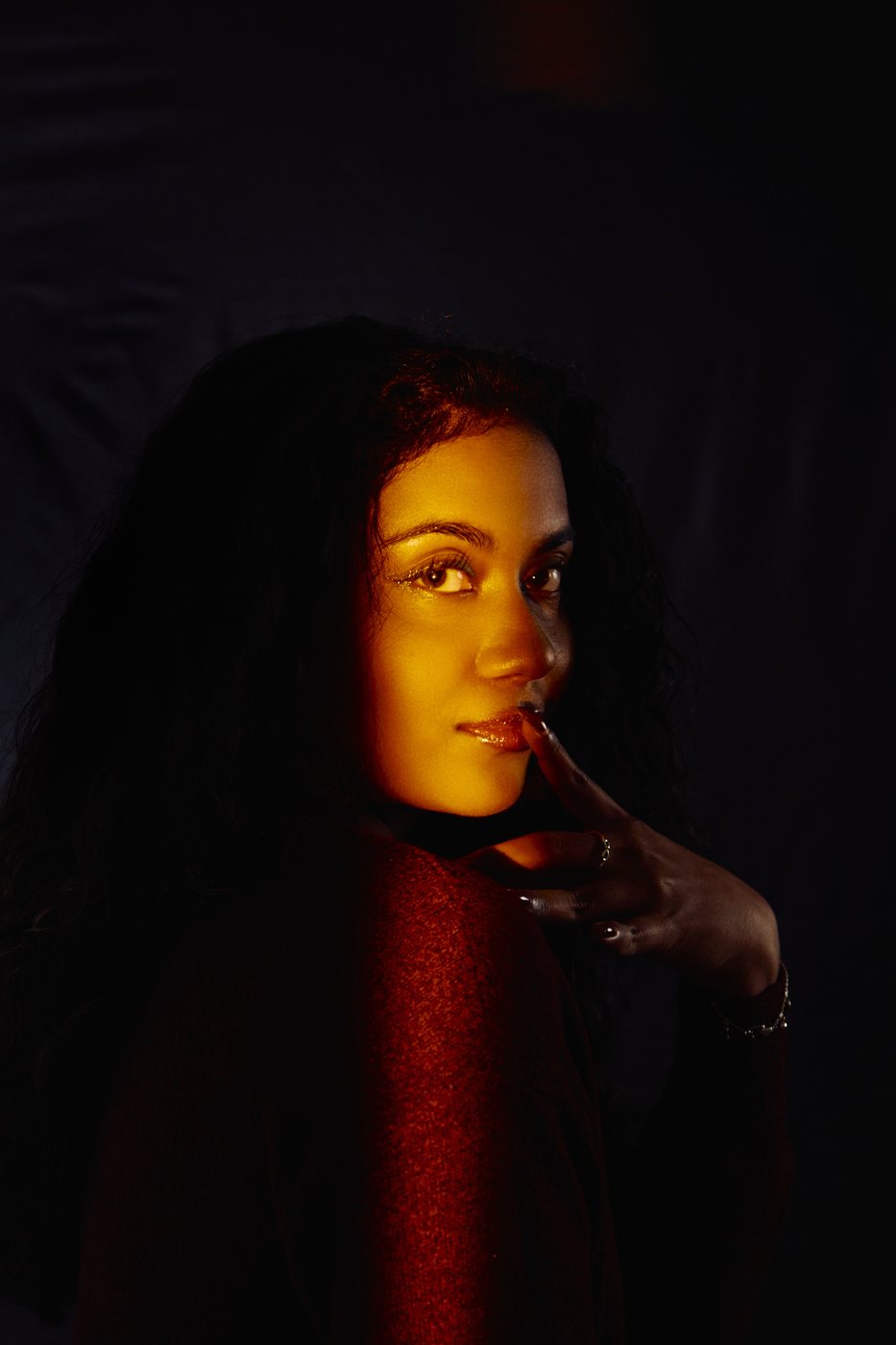 Low-light editorial portrait with red accent light